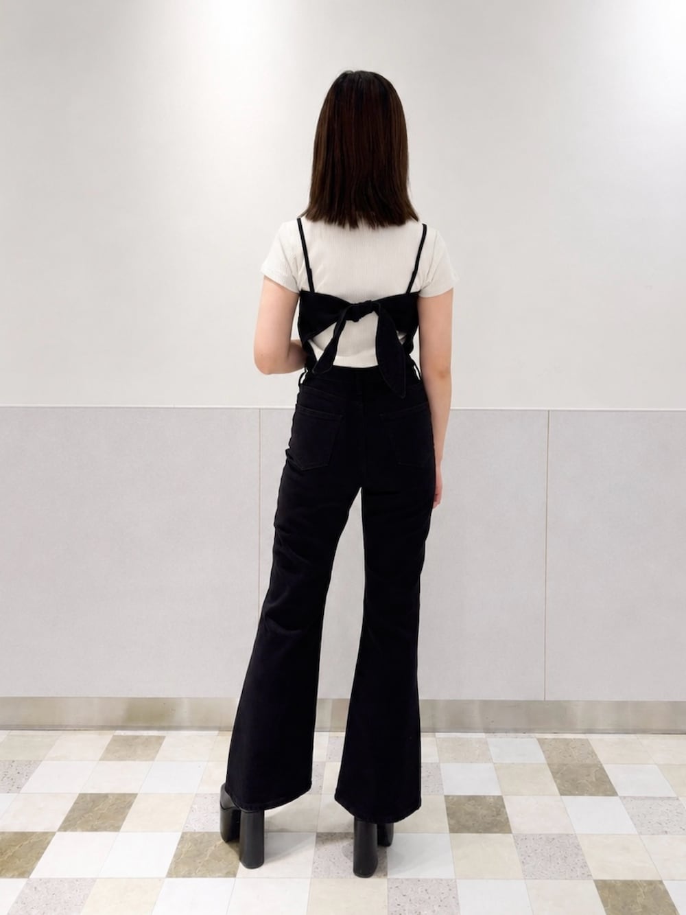 ブラック系のつなぎ/オールインワン、ホワイト系のTシャツ/カットソー、ブラック系のサンダルを着用したレディースの夏コーディネートの3枚目の写真