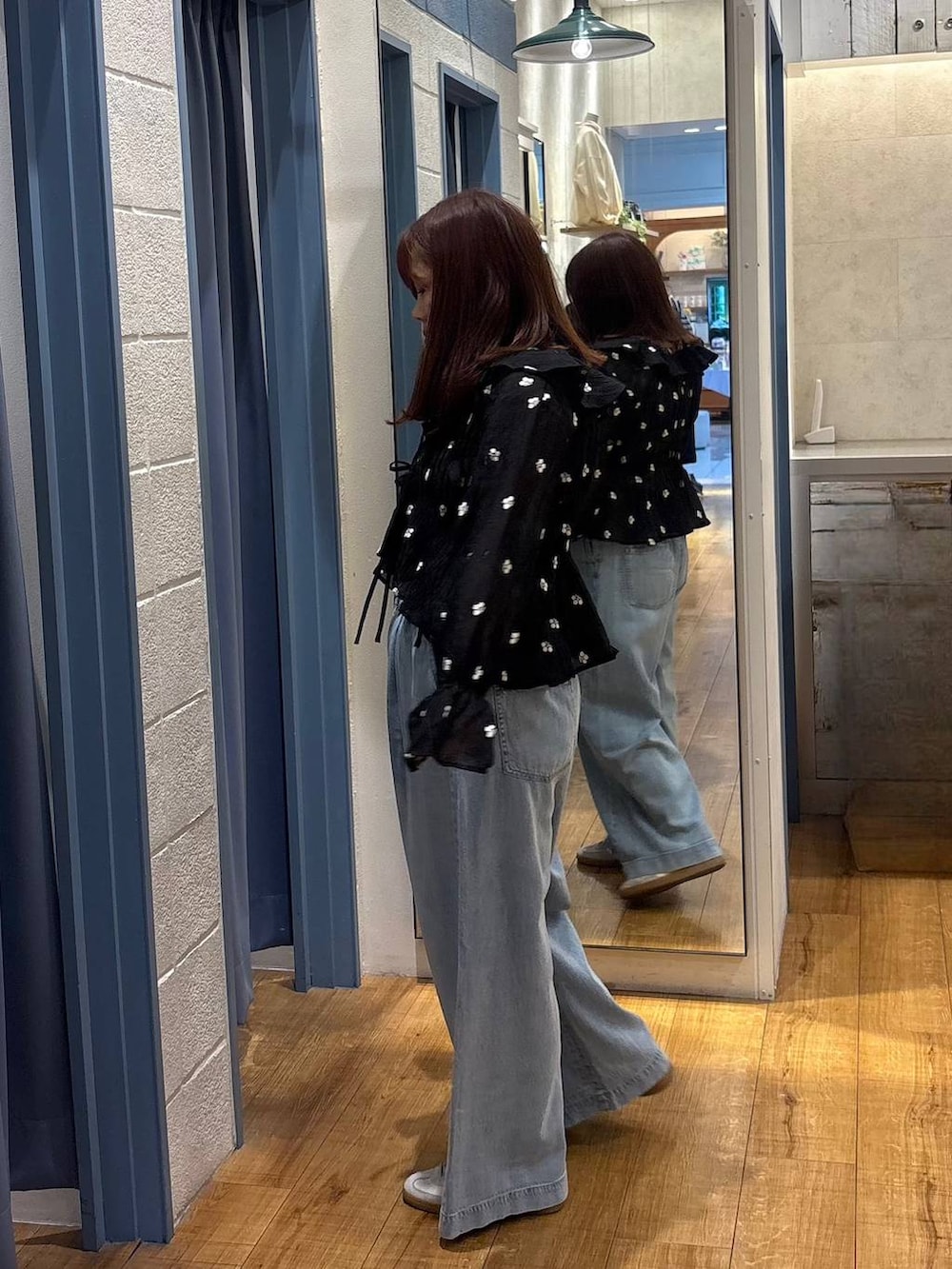 シルバー系のタンクトップ、ブルー系のデニムパンツ、ブラック系のシャツ/ブラウスを着用したレディースの春コーディネートの2枚目の写真