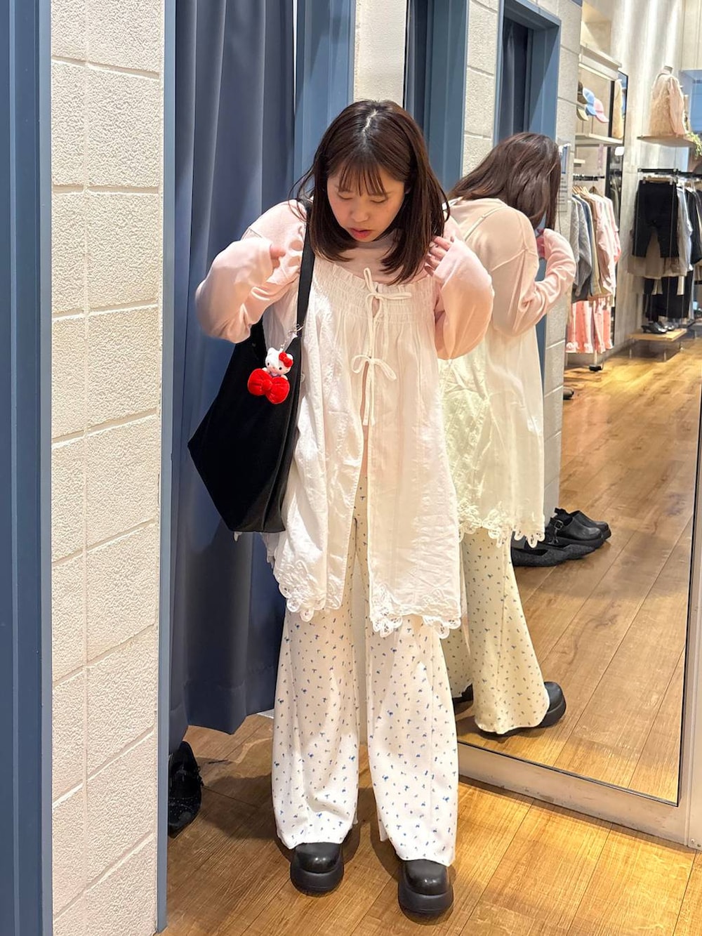 ブラック系のショルダーバッグ、ピンク系のTシャツ/カットソー、ホワイト系のその他パンツを着用したレディースの春コーディネートの2枚目の写真