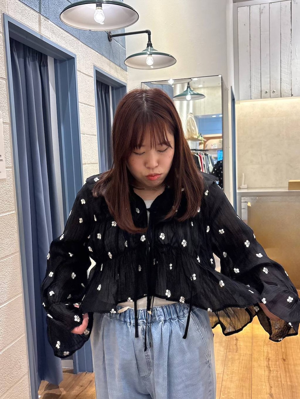 シルバー系のタンクトップ、ブルー系のデニムパンツ、ブラック系のシャツ/ブラウスを着用したレディースの春コーディネートの4枚目の写真