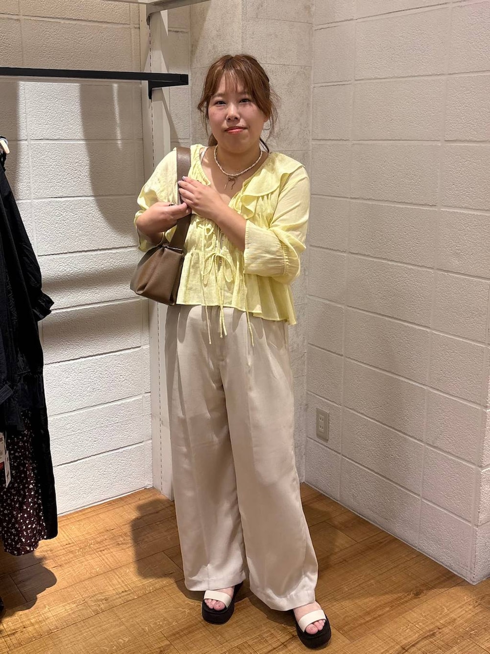 ホワイト系のTシャツ/カットソー、ホワイト系のスラックス、ホワイト系のサンダルを着用したレディースの春コーディネートの2枚目の写真