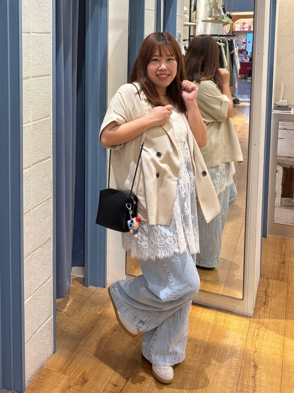 ブルー系のデニムパンツ、ホワイト系のタンクトップ、ホワイト系のテーラードジャケットを着用したレディースの春コーディネートの3枚目の写真