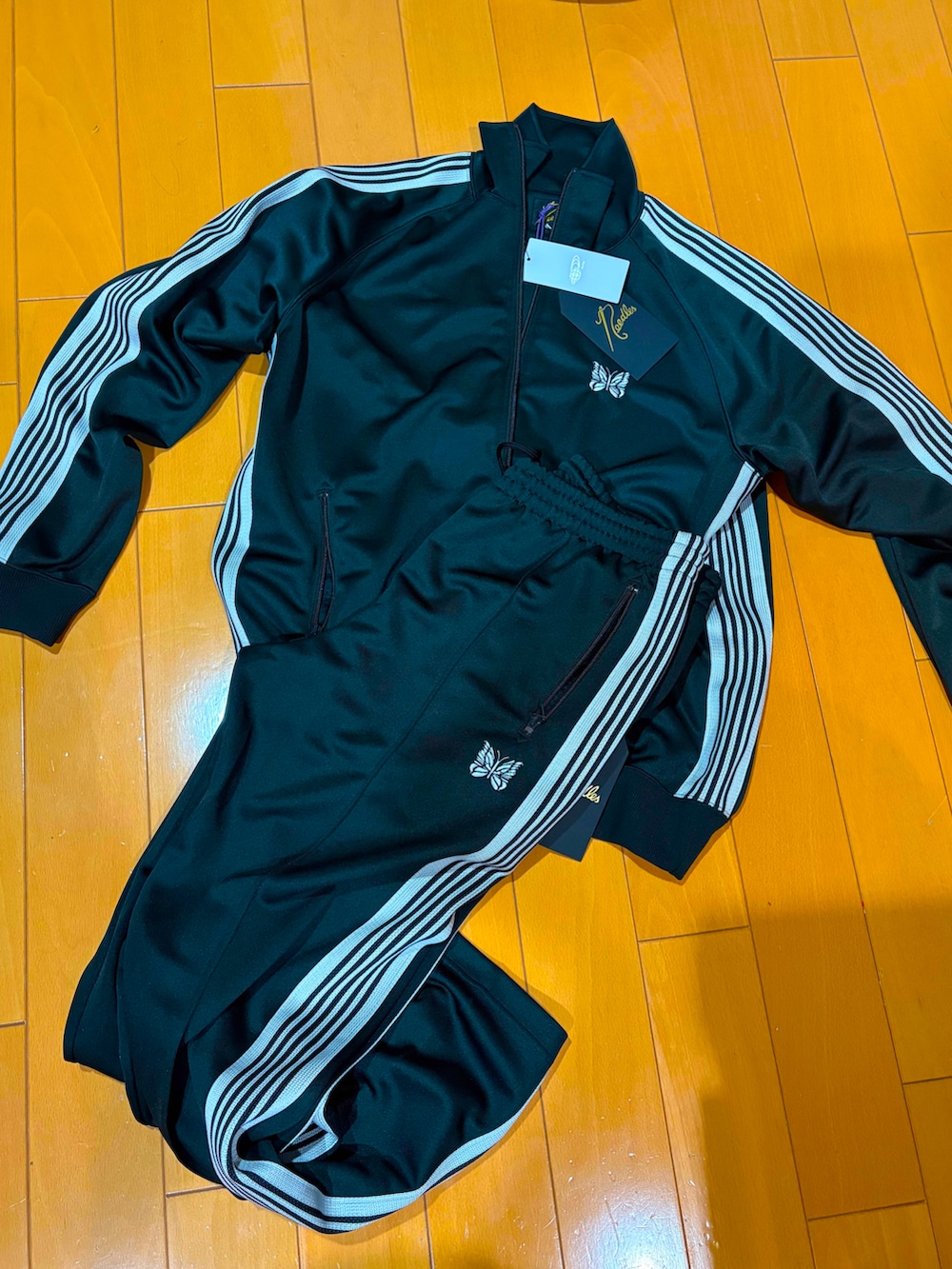 レッド系のスニーカー、ブラック系のジャージ、ブラック系のその他パンツを着用したメンズの春コーディネートの3枚目の写真