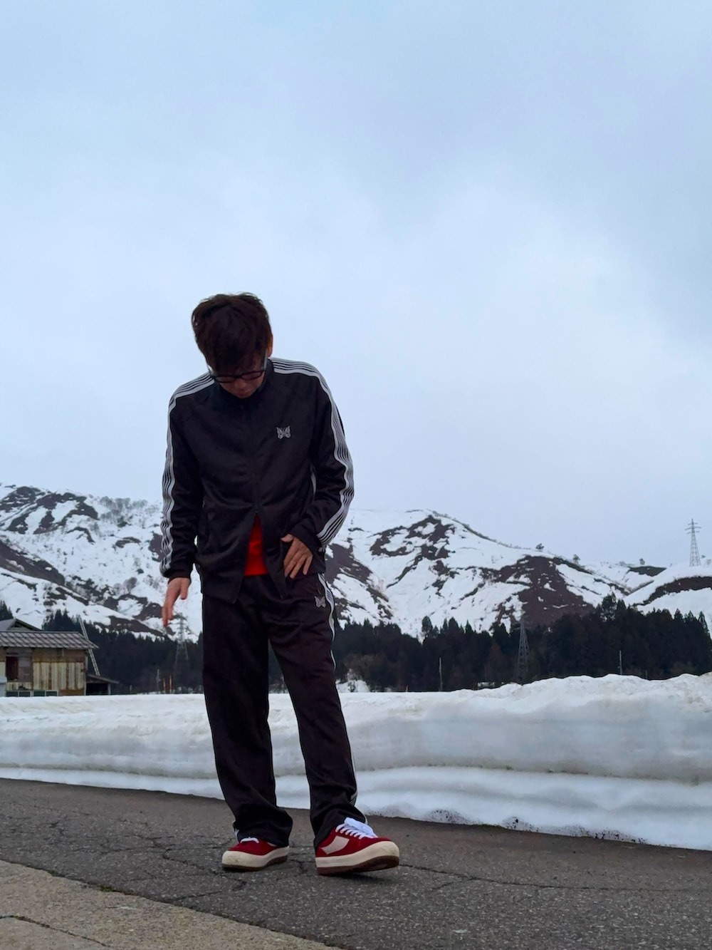 レッド系のスニーカー、ブラック系のジャージ、ブラック系のその他パンツを着用したメンズの春コーディネートの2枚目の写真