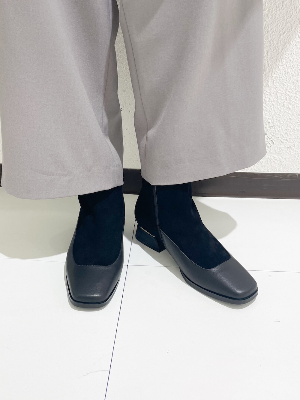 ベージュ系のショルダーバッグ、ブラック系のブーツを着用したレディースの冬コーディネートの2枚目の写真