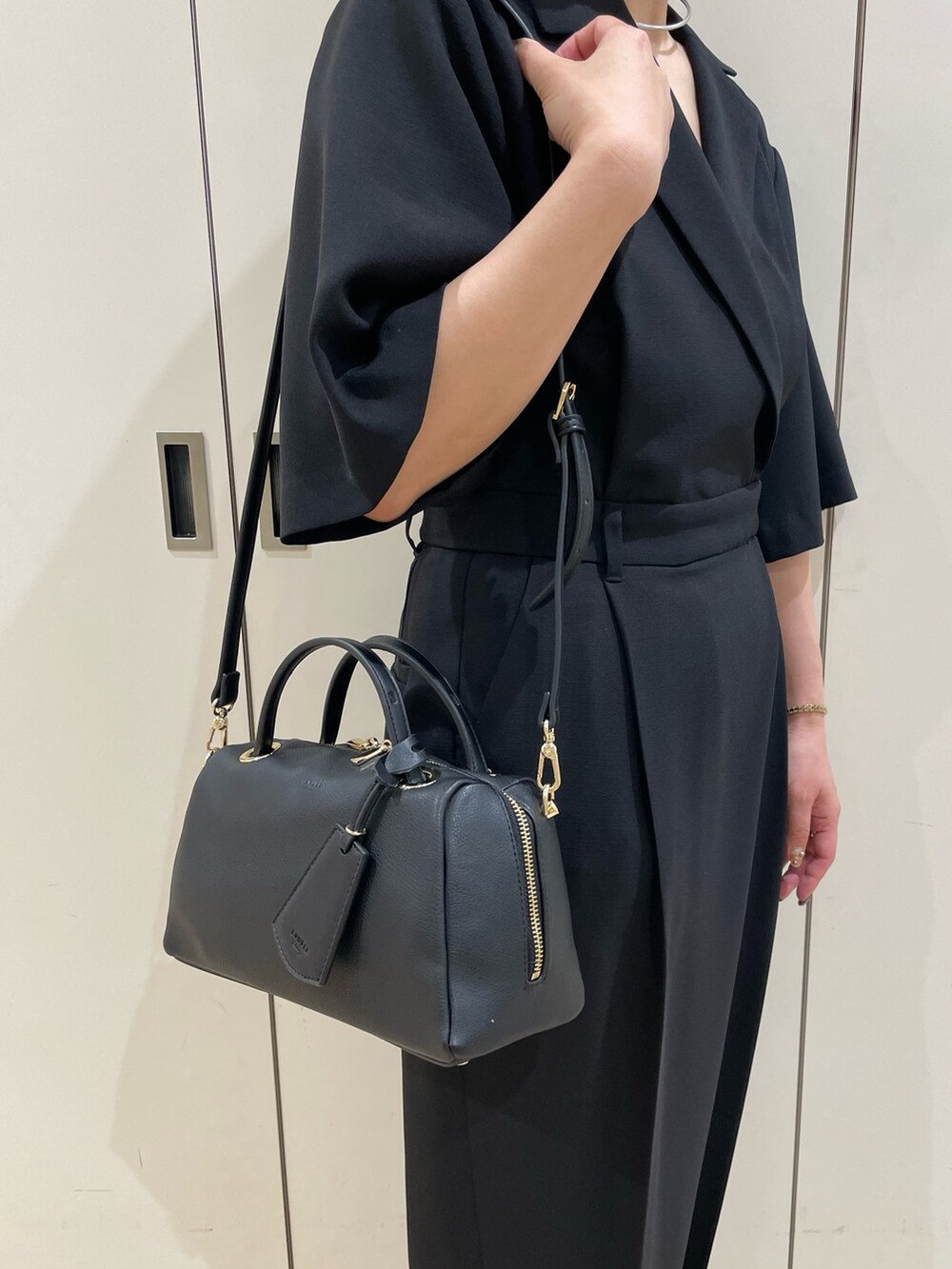 ブラック系のボストンバッグ、ブラック系のサンダルを着用したレディースの夏コーディネートの5枚目の写真