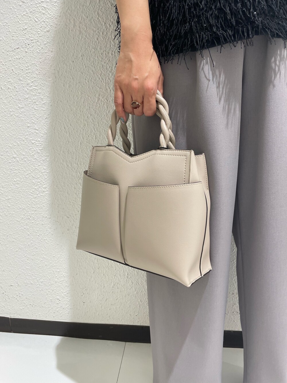 ベージュ系のショルダーバッグ、ブラック系のブーツを着用したレディースの冬コーディネートの4枚目の写真