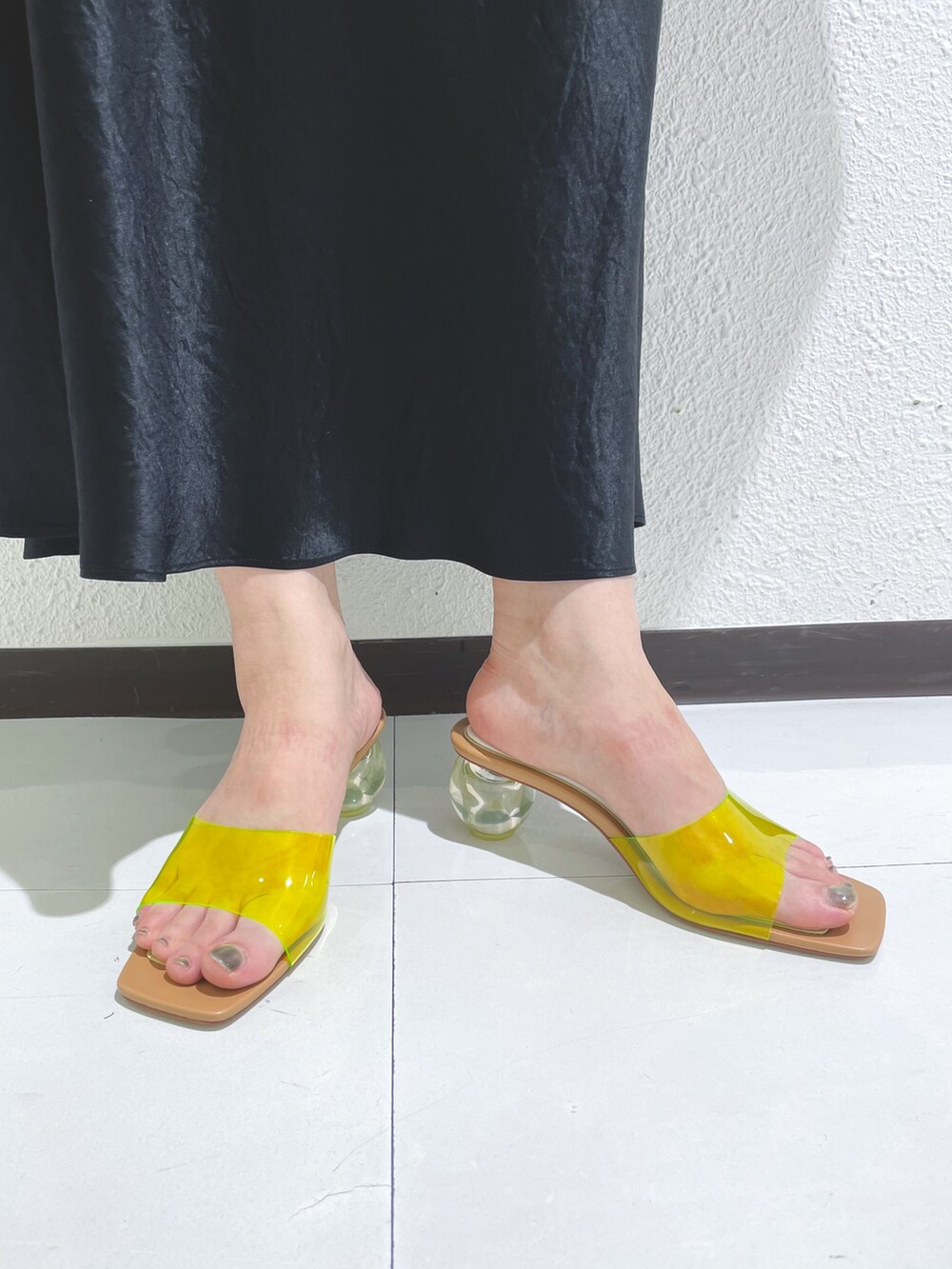 ブラック系のスカート、ブラック系のスカート、イエロー系のハンドバッグを着用したレディースの夏コーディネートの2枚目の写真