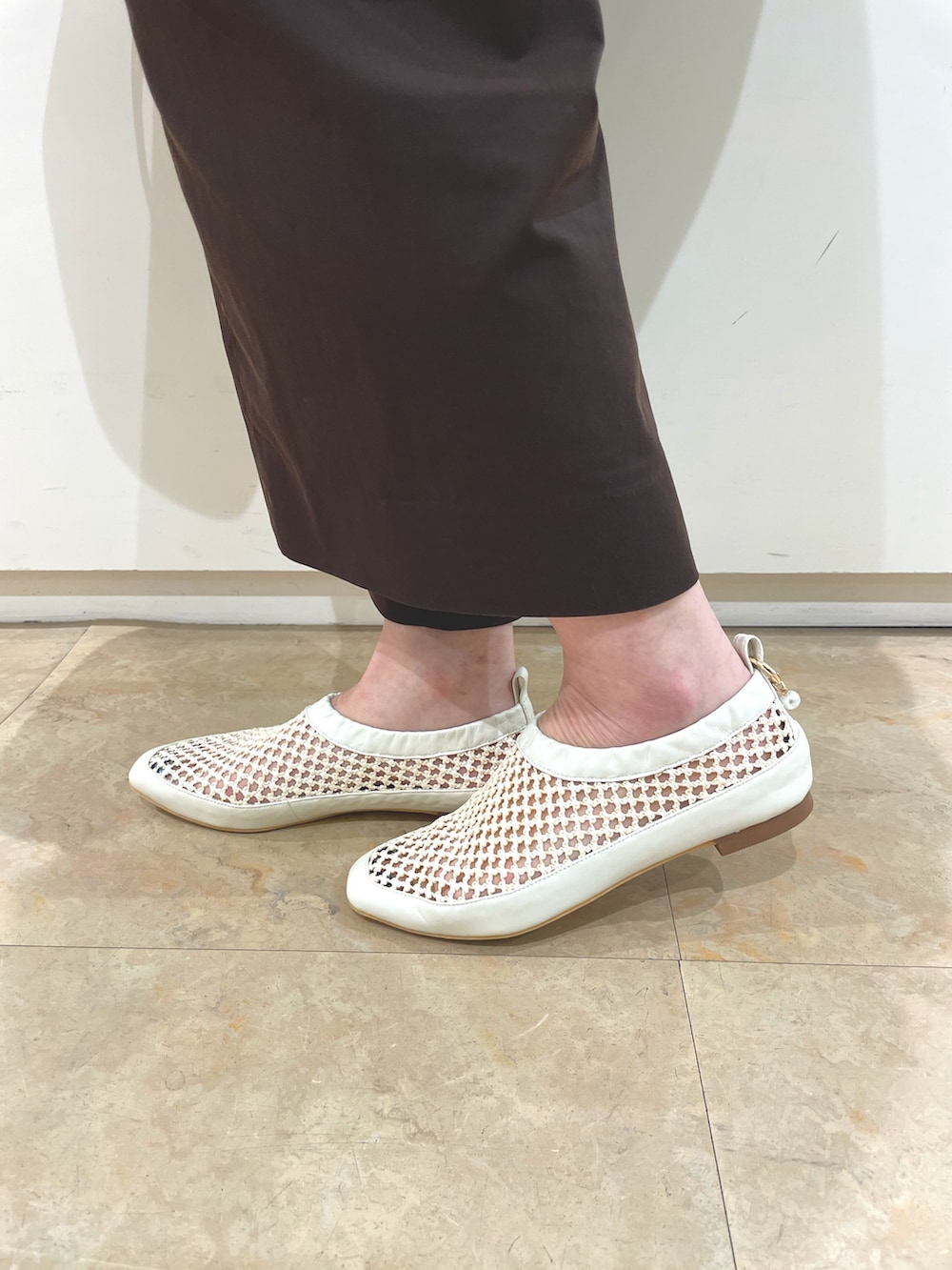 ホワイト系のサンダル、ベージュ系のトートバッグを着用したレディースの夏コーディネートの2枚目の写真