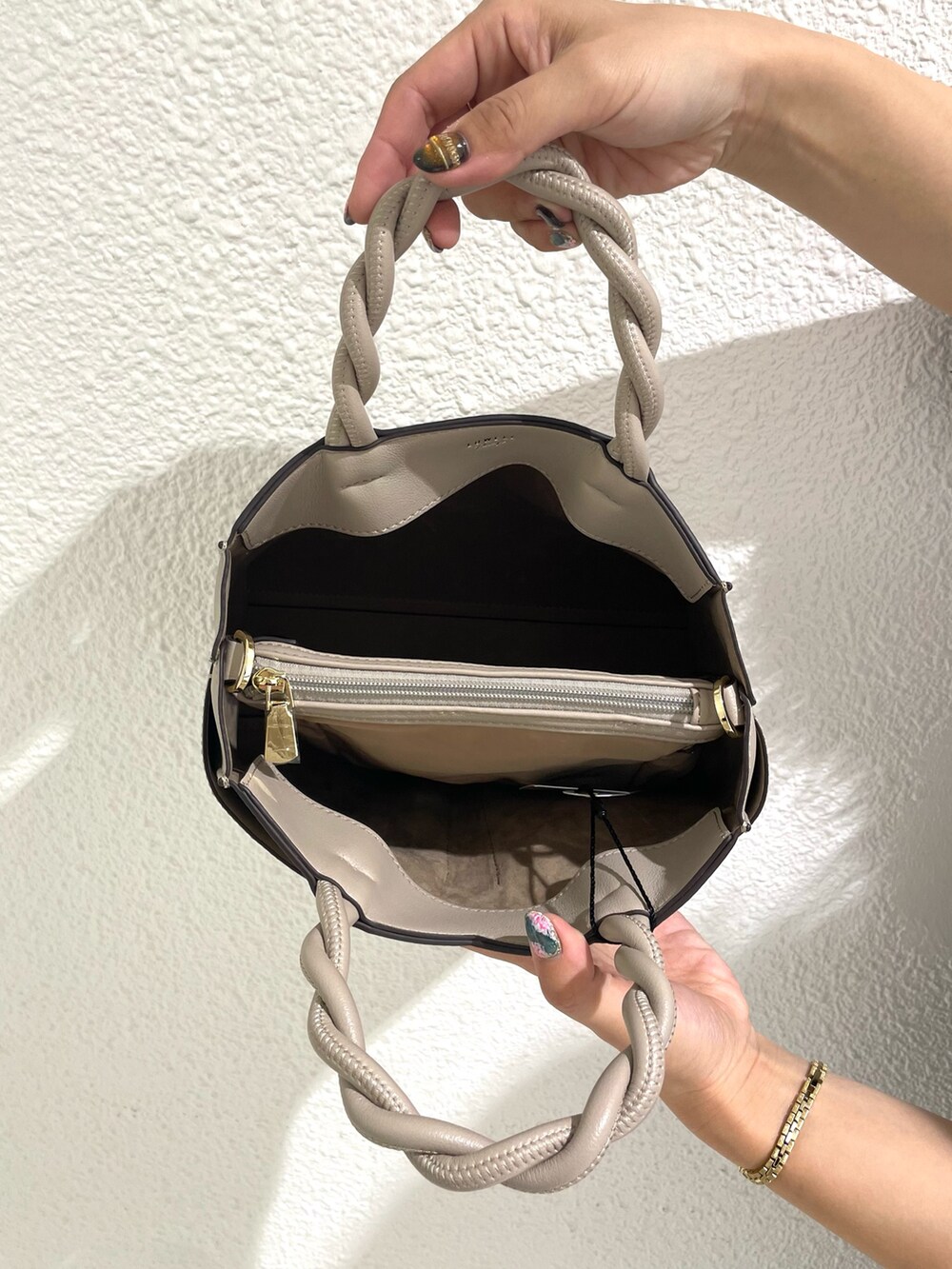 ベージュ系のショルダーバッグ、ブラック系のブーツを着用したレディースの冬コーディネートの5枚目の写真