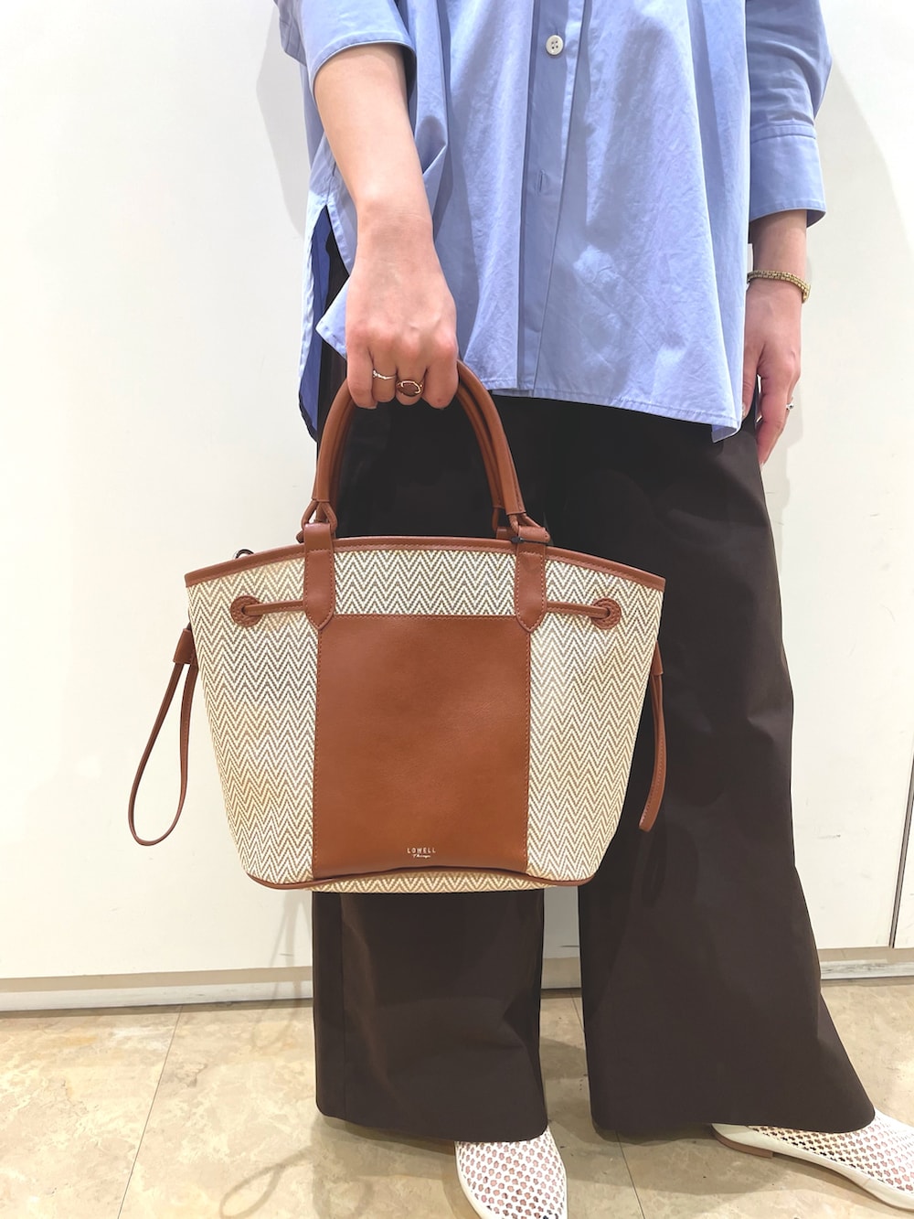 ホワイト系のサンダル、ベージュ系のトートバッグを着用したレディースの夏コーディネートの4枚目の写真