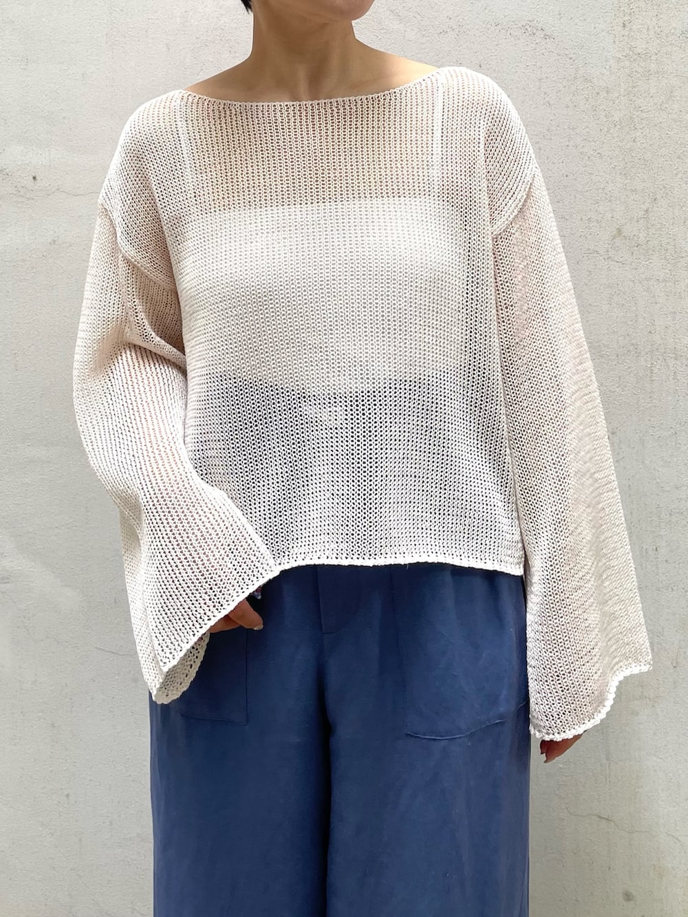 ベージュ系のニット/セーター、ブルー系のその他パンツ、その他のトートバッグを着用したレディースの夏コーディネートの2枚目の写真