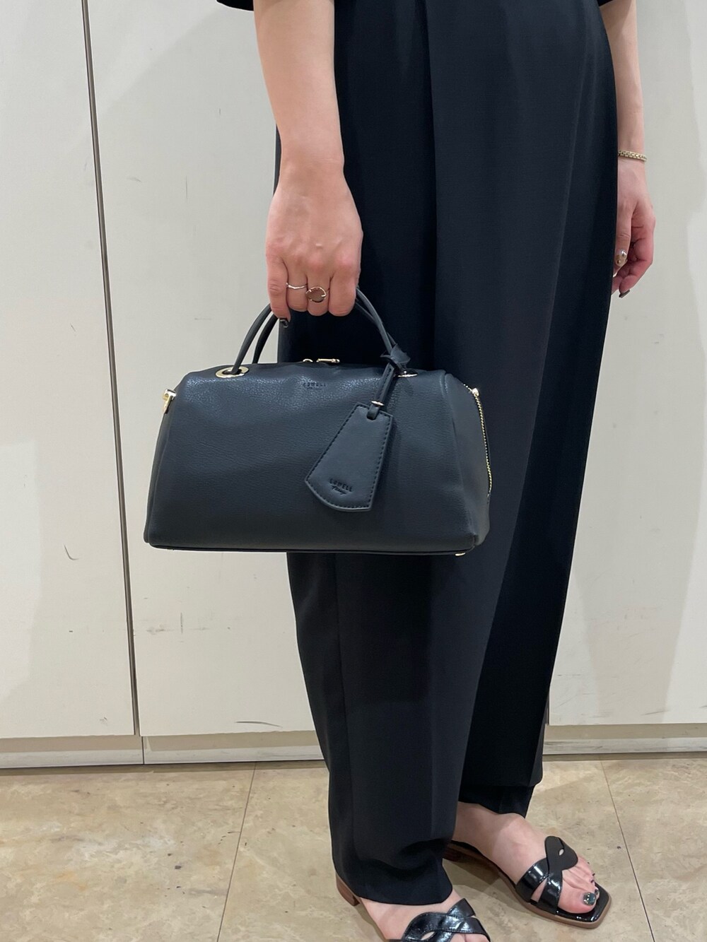 ブラック系のボストンバッグ、ブラック系のサンダルを着用したレディースの夏コーディネートの4枚目の写真