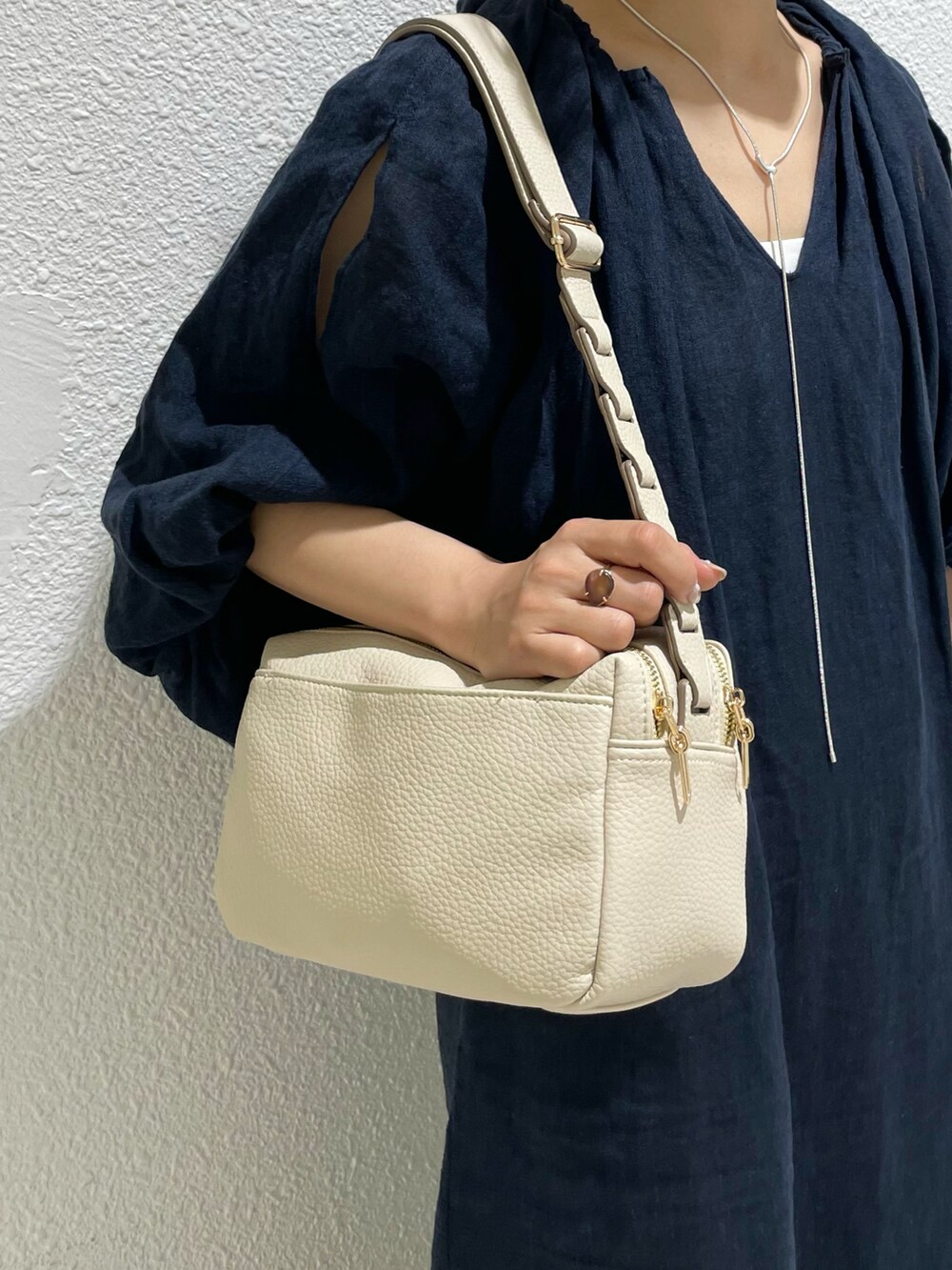 ベージュ系のレインシューズ、ホワイト系のショルダーバッグを着用したレディースの夏コーディネートの5枚目の写真