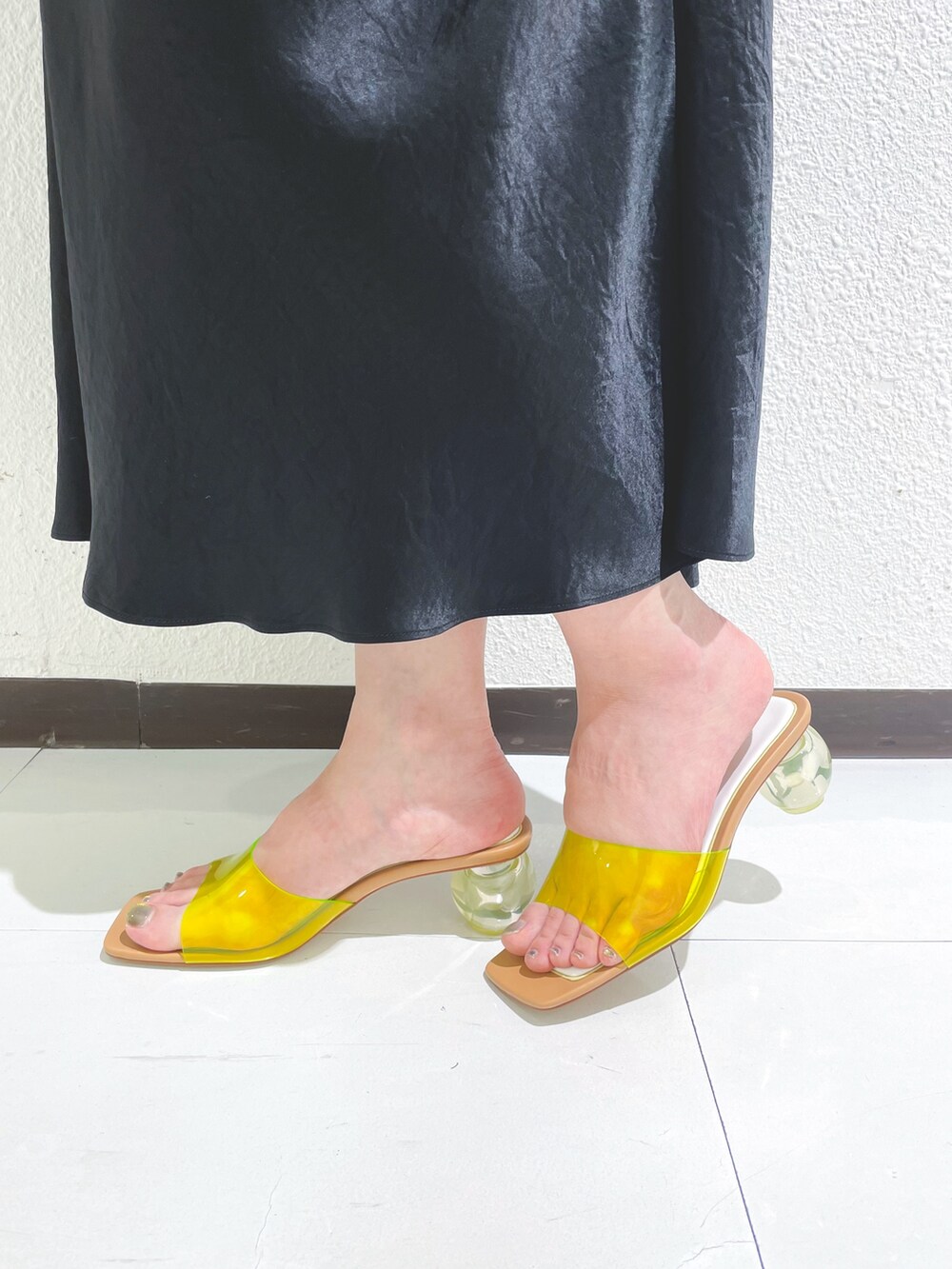 ブラック系のスカート、ブラック系のスカート、イエロー系のハンドバッグを着用したレディースの夏コーディネートの3枚目の写真