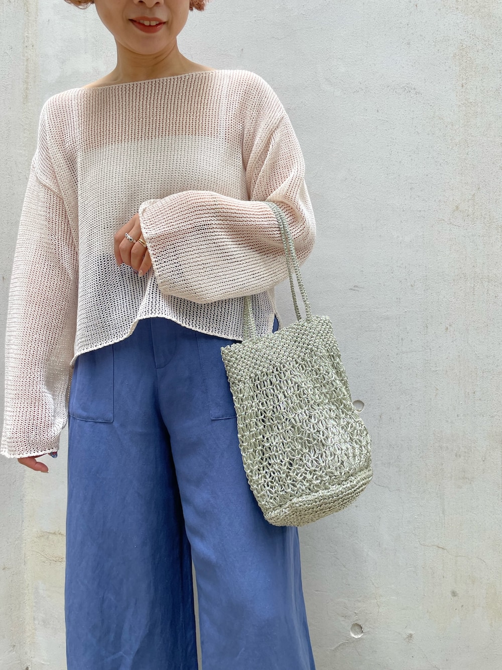 ベージュ系のニット/セーター、ブルー系のその他パンツ、その他のトートバッグを着用したレディースの夏コーディネートの4枚目の写真