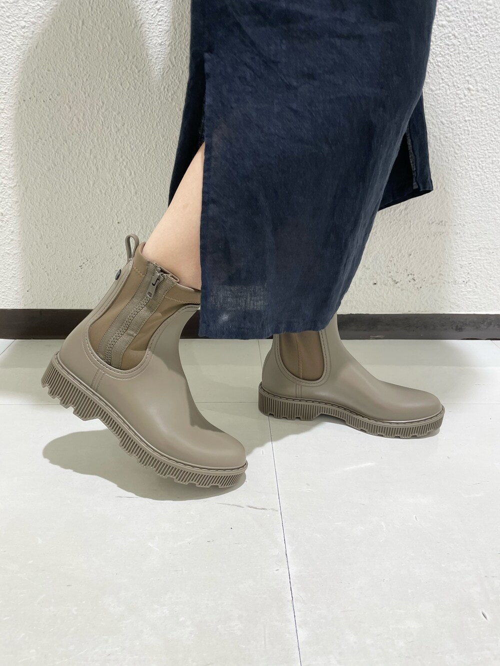 ベージュ系のレインシューズ、ホワイト系のショルダーバッグを着用したレディースの夏コーディネートの4枚目の写真