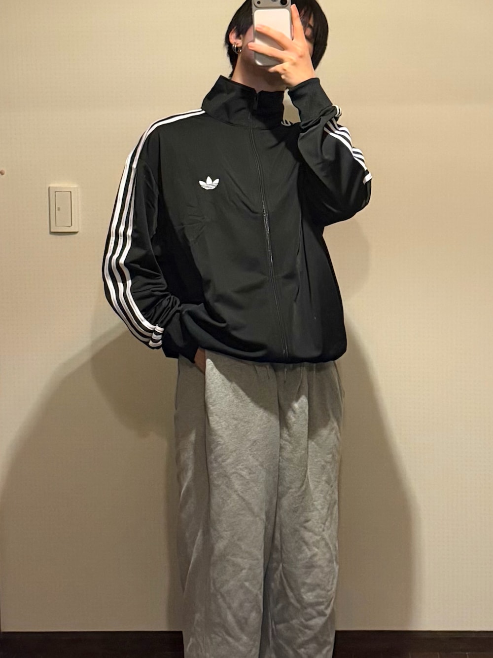 ブラック系のジャージ、グレー系のパンツを着用したメンズの冬コーディネートの2枚目の写真