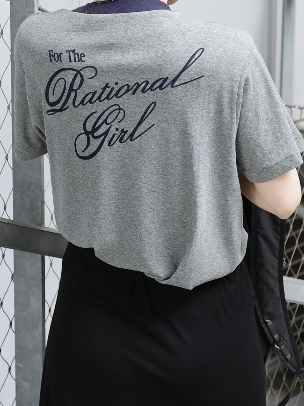 ブラック系のスカート、グレー系のTシャツ/カットソー、ブラック系のバックパック/リュックを着用したレディースの夏コーディネートの3枚目の写真