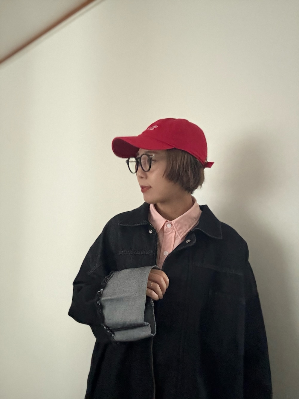 ブラック系のデニムジャケット、ピンク系のシャツ/ブラウス、ブラック系のデニムパンツを着用したレディースの秋コーディネートの2枚目の写真