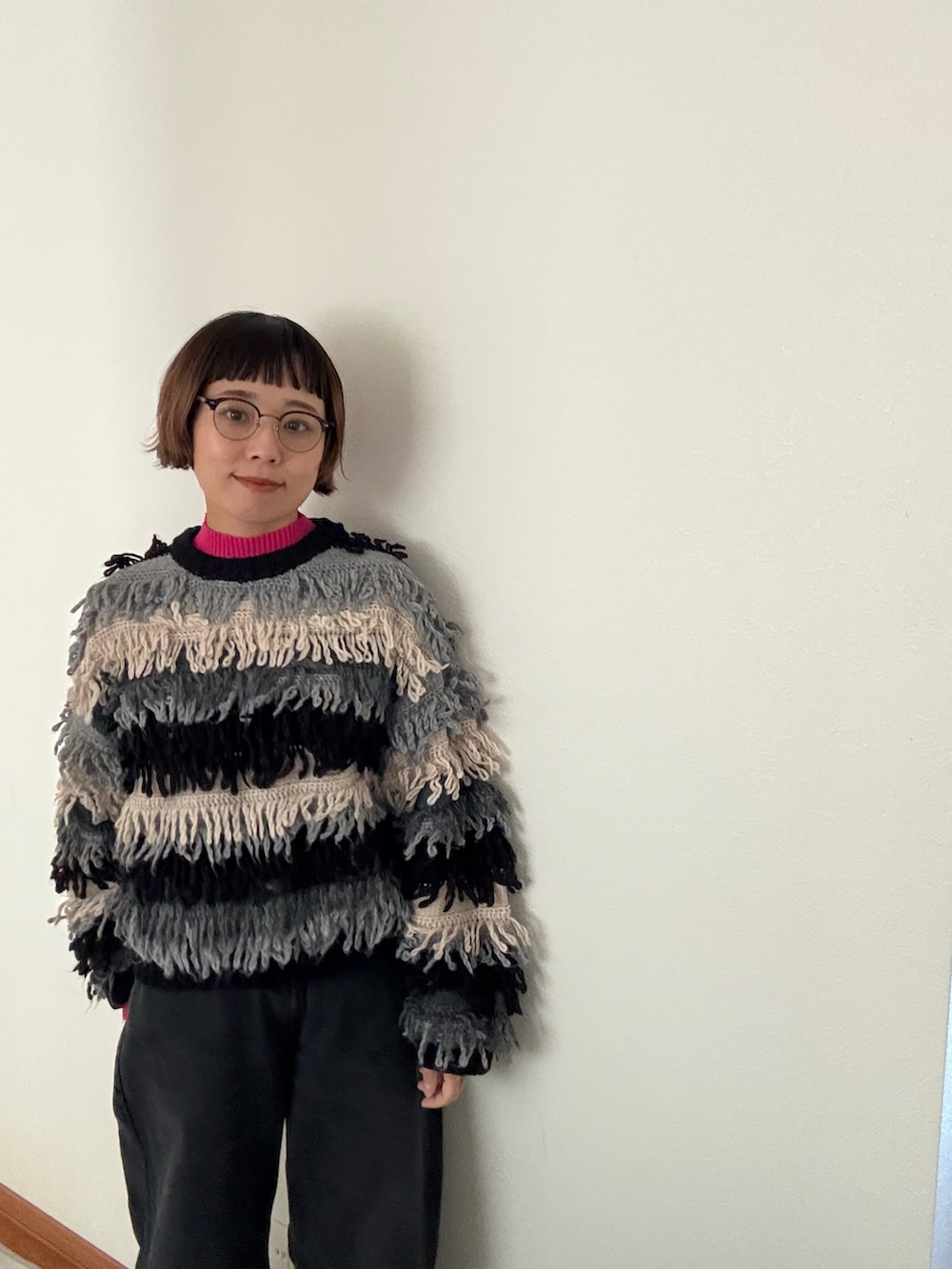 ブラック系のニット/セーター、ブルー系のニット/セーター、ブラック系のデニムパンツを着用したレディースの秋コーディネートの3枚目の写真