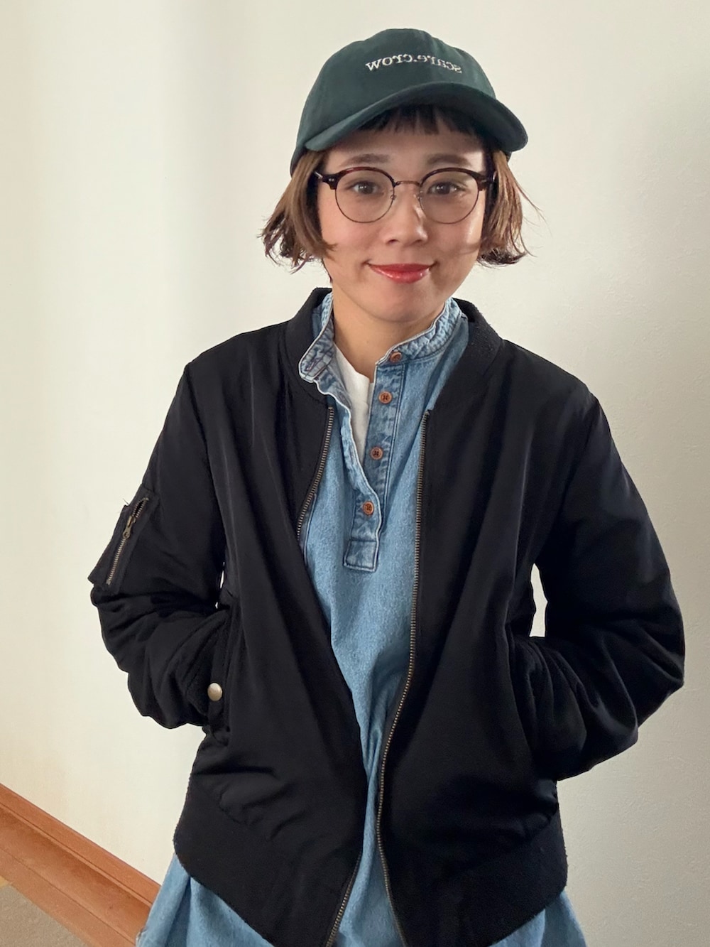 グリーン系のキャップを着用したレディースの秋コーディネートの3枚目の写真