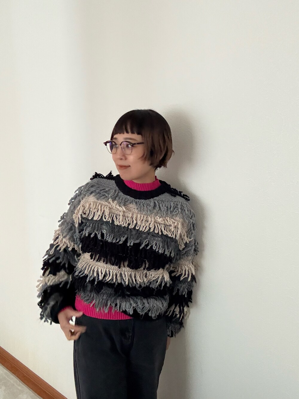 ブラック系のニット/セーター、ブルー系のニット/セーター、ブラック系のデニムパンツを着用したレディースの秋コーディネートの2枚目の写真