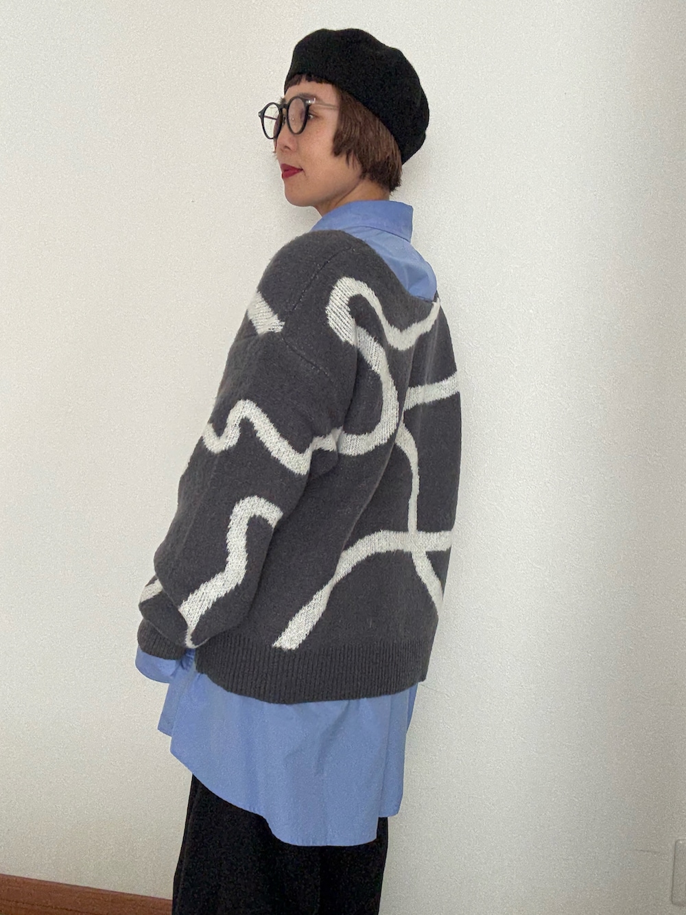 グレー系のニット/セーター、ブルー系のシャツ/ブラウスを着用したレディースの秋コーディネートの3枚目の写真