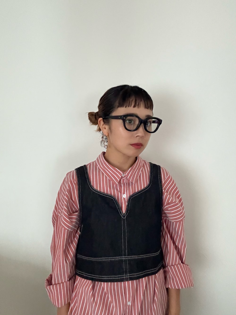 ブラック系のデニムパンツ、ブラック系のベストを着用したレディースの秋コーディネートの2枚目の写真