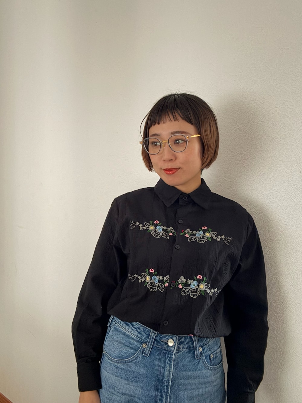 ブラック系のシャツ/ブラウス、ブルー系のデニムパンツを着用したレディースの秋コーディネートの3枚目の写真