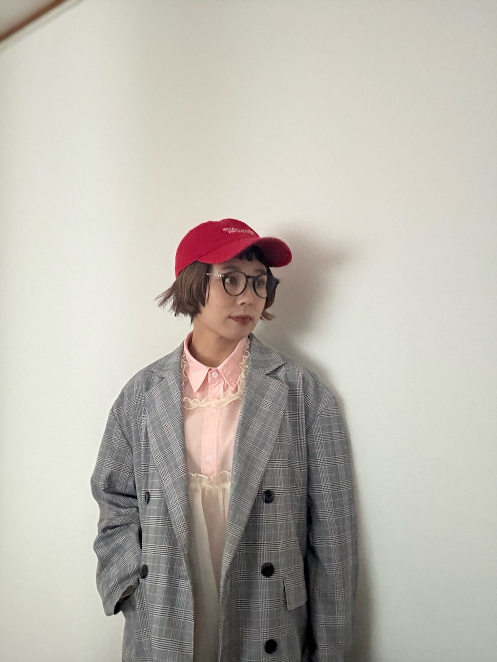 グレー系のテーラードジャケット、ピンク系のシャツ/ブラウス、ブラック系のデニムパンツを着用したレディースの秋コーディネートの2枚目の写真