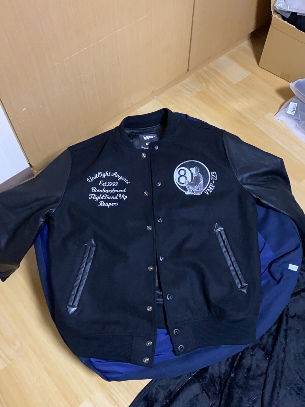 グレー系のスウェットパンツ、グレー系のテーラードジャケット、ブラック系のスタジャンを着用したメンズの冬コーディネートの4枚目の写真