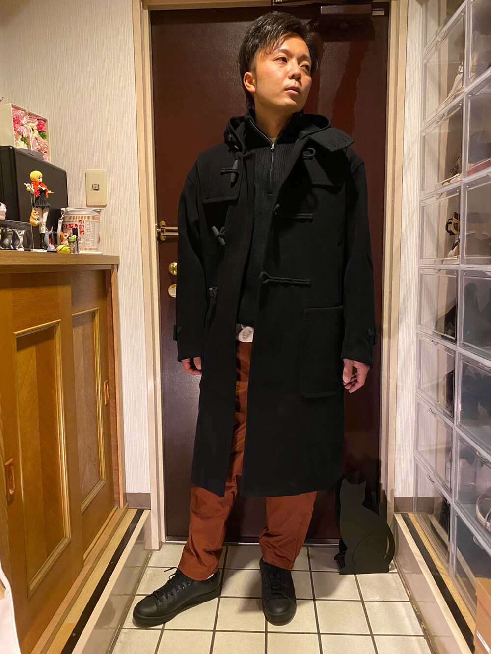 ブラック系のニット/セーター、オレンジ系のその他パンツ、ブラック系のスニーカーを着用したメンズの冬コーディネートの2枚目の写真