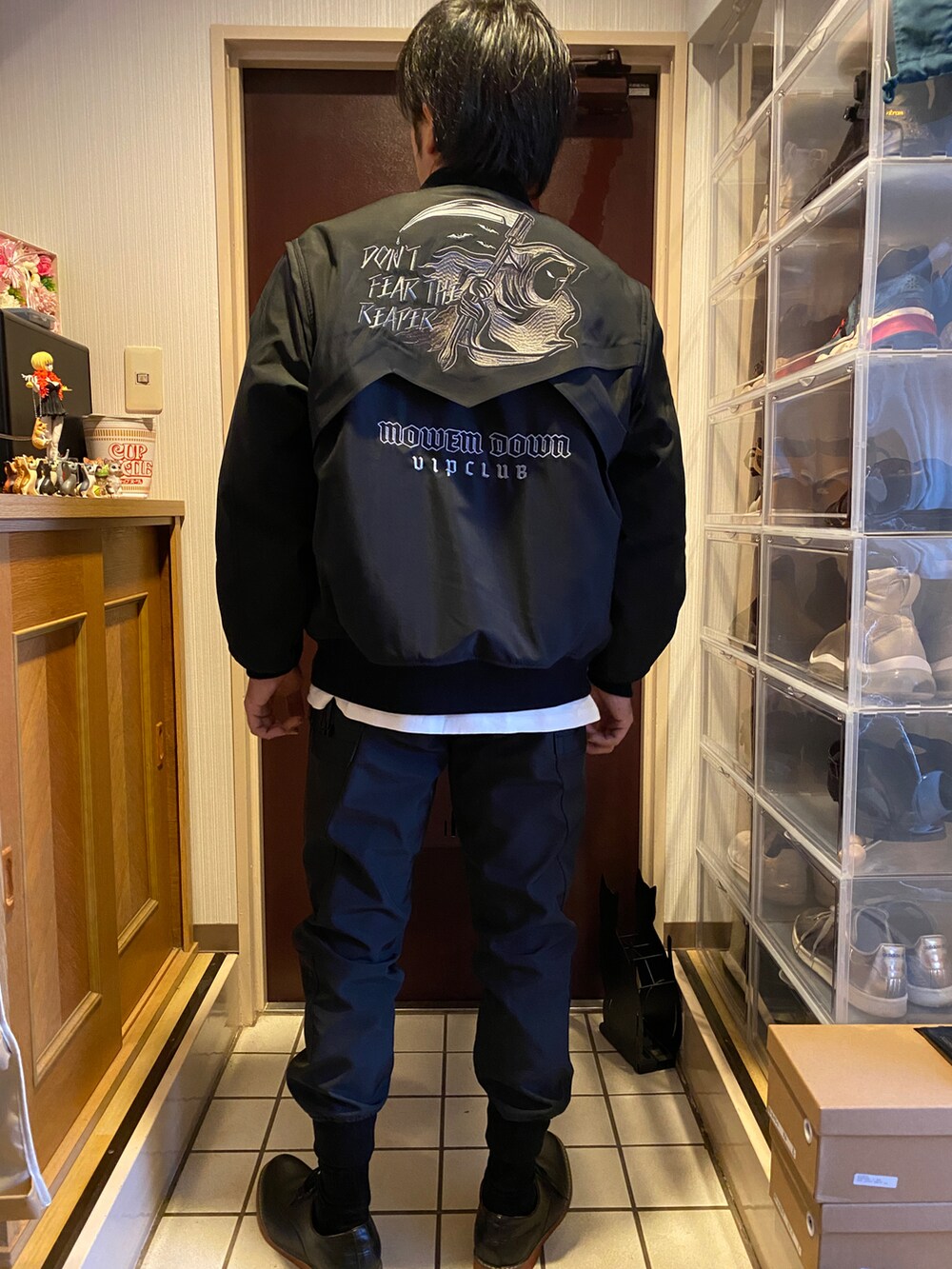 ブラック系のスタジャン、ホワイト系のTシャツ/カットソー、ブラック系のカーゴパンツを着用したメンズの冬コーディネートの2枚目の写真