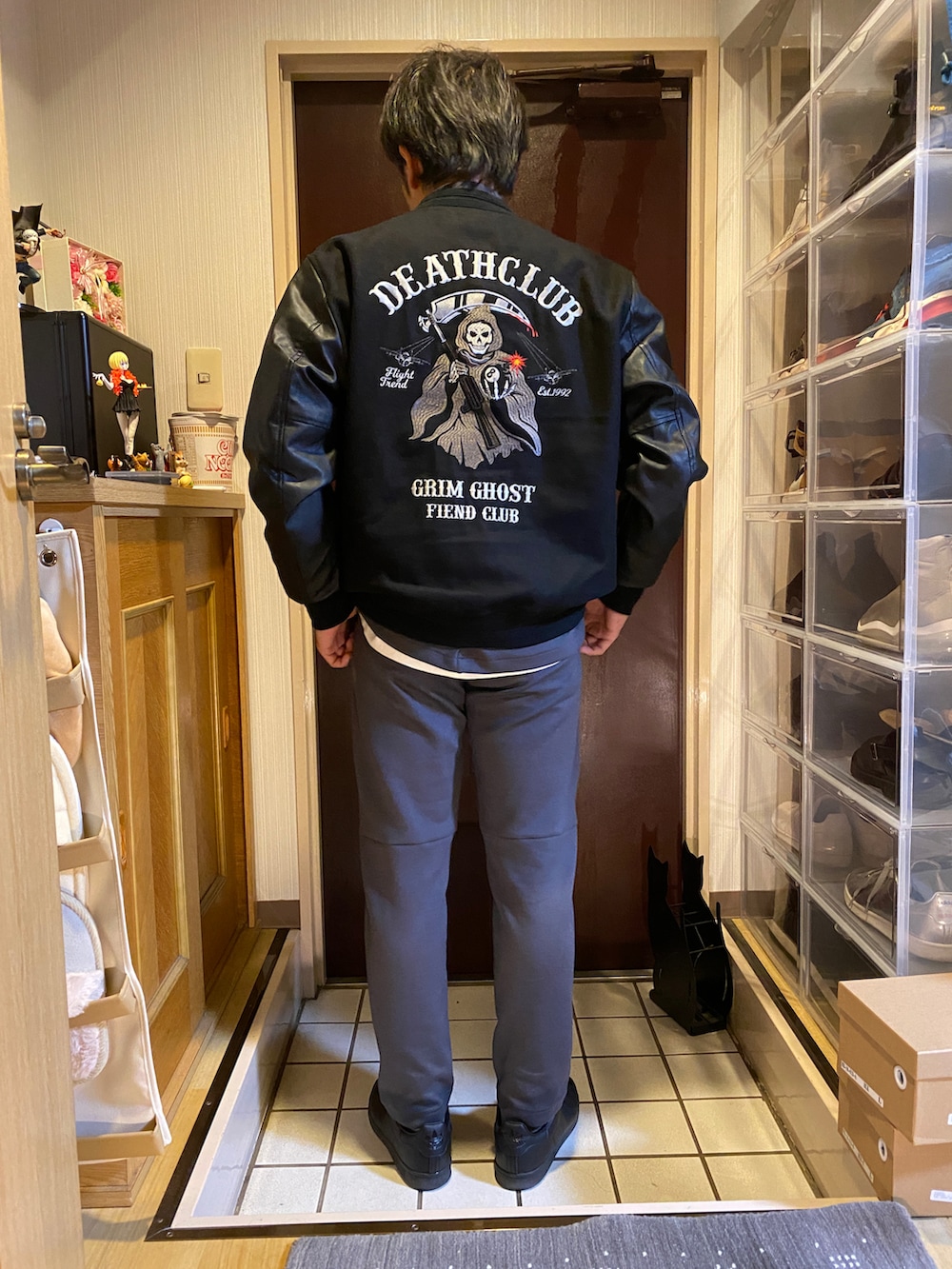 グレー系のスウェットパンツ、グレー系のテーラードジャケット、ブラック系のスタジャンを着用したメンズの冬コーディネートの2枚目の写真