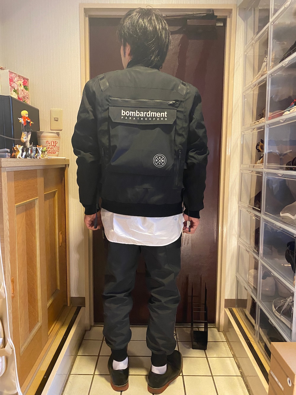 ブラック系のカーゴパンツ、ホワイト系のシャツ/ブラウス、ブラック系のミリタリージャケットを着用したメンズの冬コーディネートの2枚目の写真