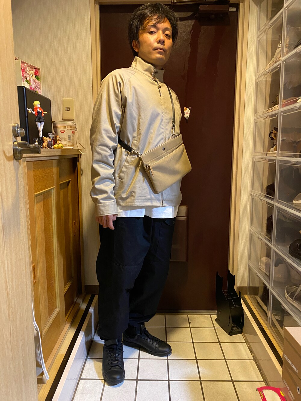 ブラック系のその他パンツ、ブラック系のスニーカー、ベージュ系のショルダーバッグを着用したメンズの秋コーディネートの2枚目の写真