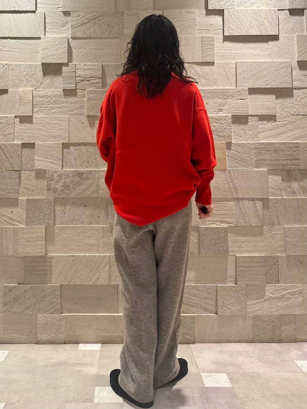 ブラック系のブーツ、グレー系のその他パンツ、レッド系のニット/セーターを着用したレディースの冬コーディネートの3枚目の写真