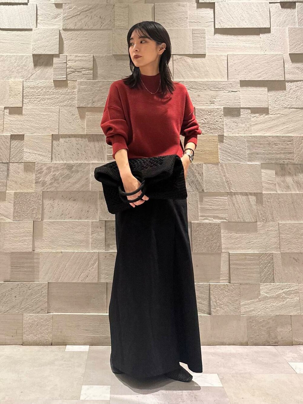 ブラック系のパンプス、ブラック系のトートバッグ、レッド系のニット/セーターを着用したレディースの秋コーディネートの3枚目の写真