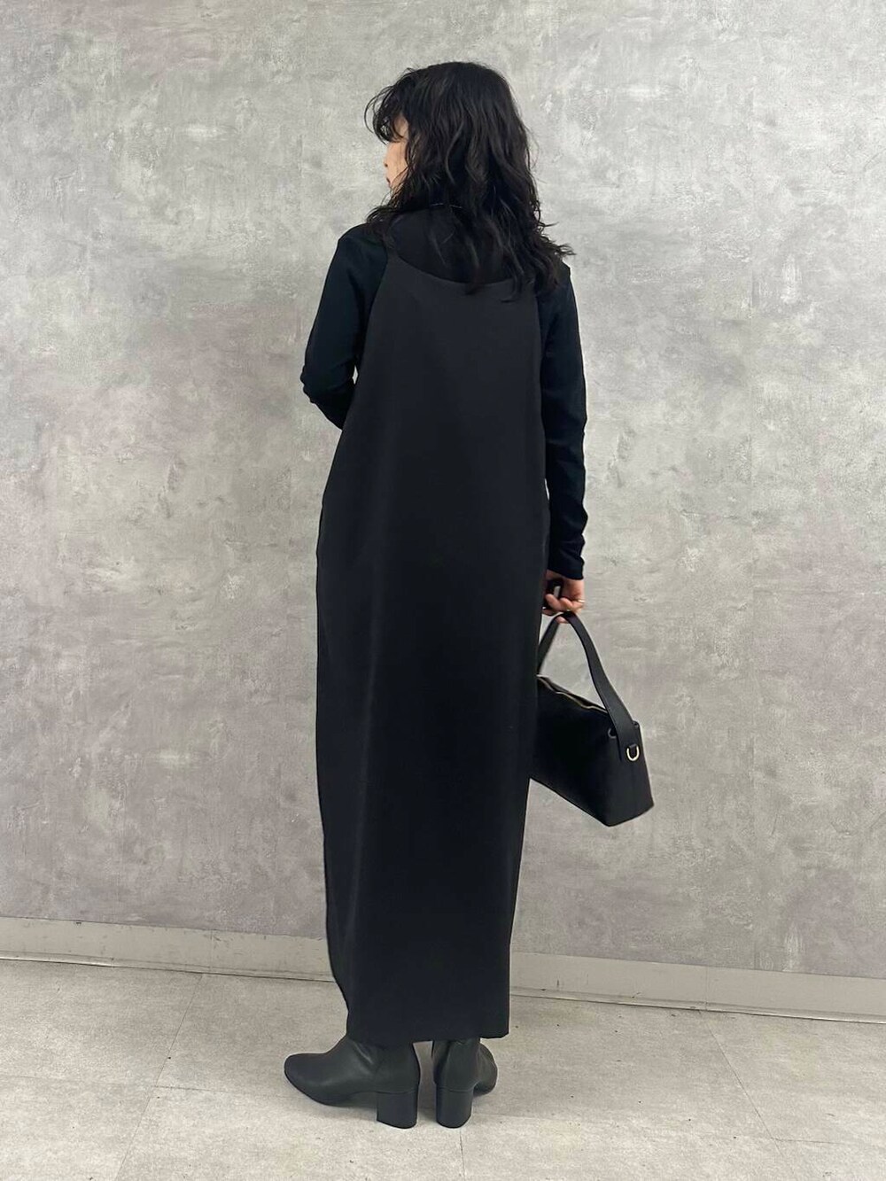 ブラック系のブーツ、ブラック系のTシャツ/カットソー、ブラック系のショルダーバッグを着用したレディースの冬コーディネートの3枚目の写真