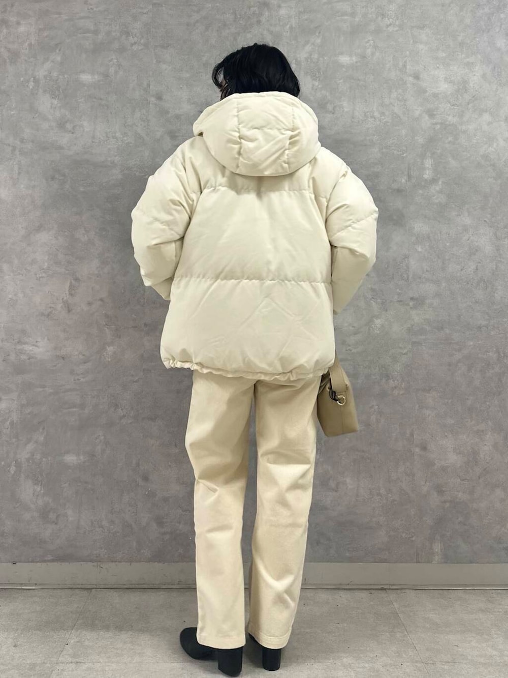 ブラック系のブーツ、ホワイト系のダウンジャケット/コート、ベージュ系のデニムパンツを着用したレディースの冬コーディネートの6枚目の写真