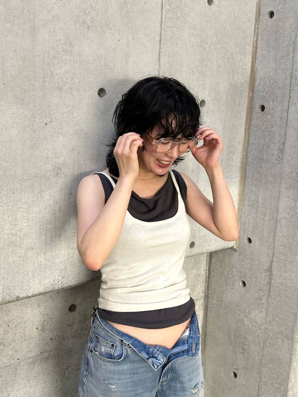 ホワイト系のキャミソール、グレー系のタンクトップ、ブルー系のデニムパンツを着用したレディースの夏コーディネートの4枚目の写真