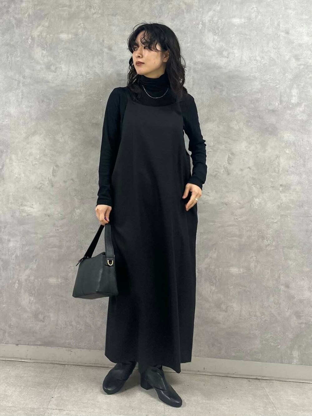 ブラック系のブーツ、ブラック系のTシャツ/カットソー、ブラック系のショルダーバッグを着用したレディースの冬コーディネートの5枚目の写真