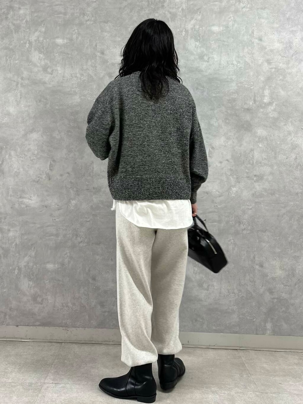 ブラック系のショルダーバッグ、ブラック系のブーツ、ホワイト系のTシャツ/カットソーを着用したレディースの冬コーディネートの6枚目の写真