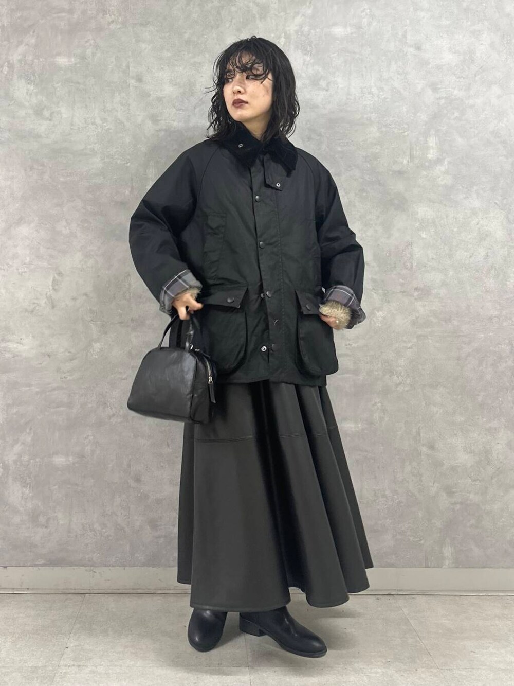 ブラック系のその他アウター、ブラック系のショルダーバッグ、ブラック系のスカートを着用したレディースの冬コーディネートの5枚目の写真