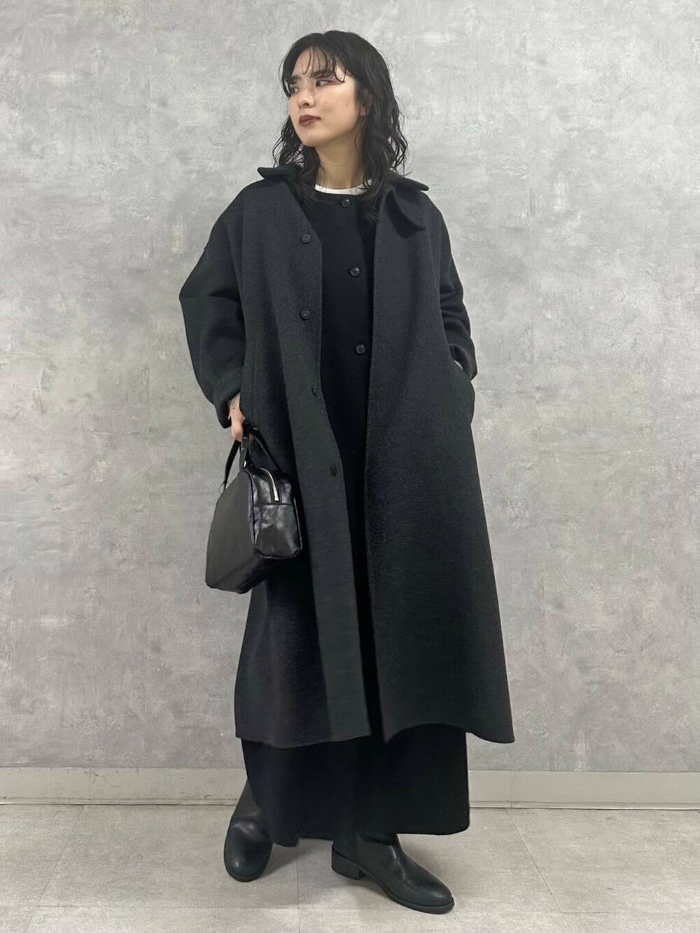 ブラック系のショルダーバッグ、グレー系のステンカラーコート、ホワイト系のシャツ/ブラウスを着用したレディースの冬コーディネートの2枚目の写真