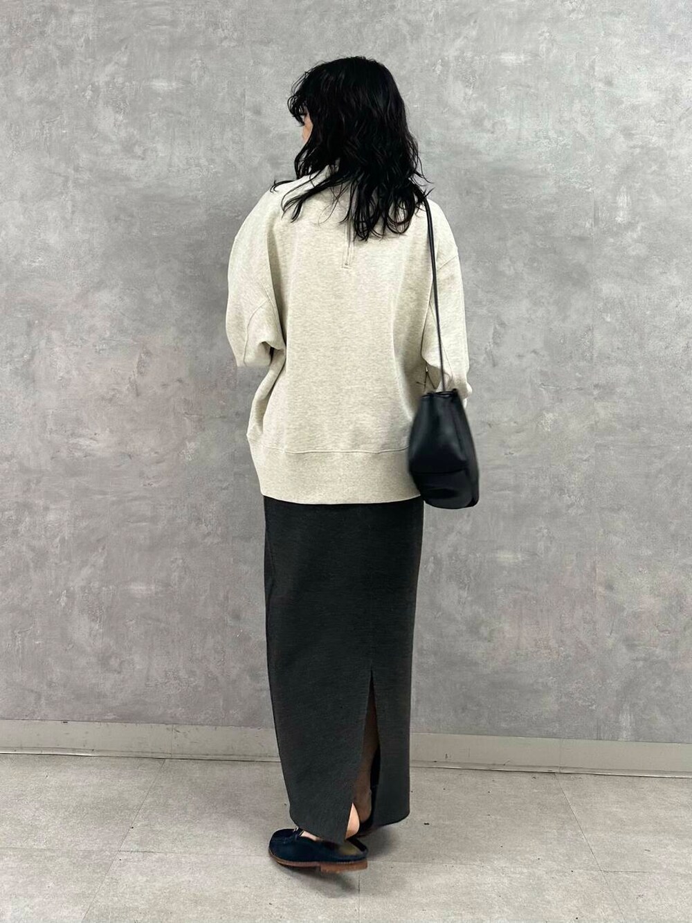 グレー系のスカート、ブラック系のショルダーバッグ、ホワイト系のTシャツ/カットソーを着用したレディースの冬コーディネートの4枚目の写真