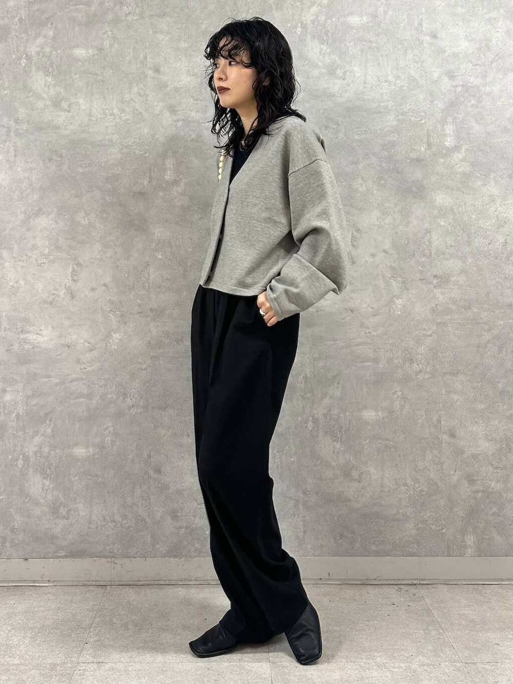 ブラック系のその他パンツ、グレー系のカーディガン/ボレロ、ブラック系のショルダーバッグを着用したレディースの冬コーディネートの4枚目の写真