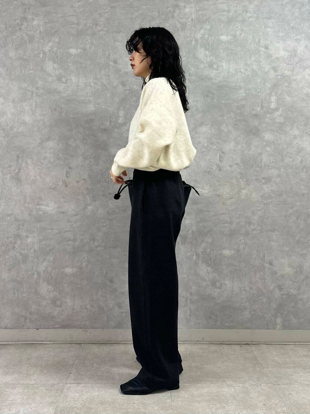 ホワイト系のTシャツ/カットソー、ブラック系のショルダーバッグ、ホワイト系のニット/セーターを着用したレディースの冬コーディネートの3枚目の写真