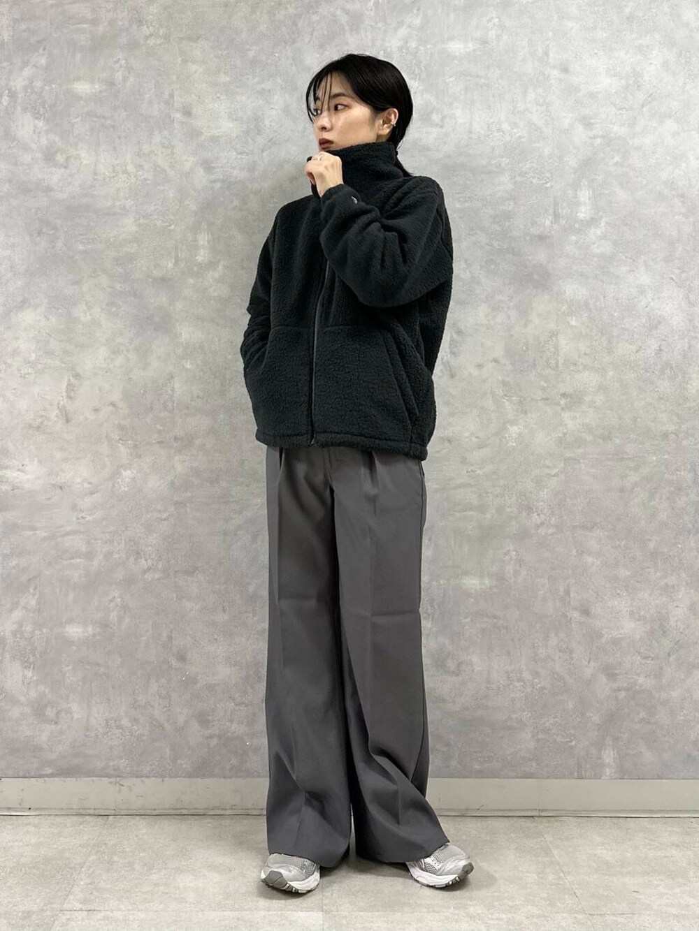 ブラック系のその他アウター、グレー系のその他パンツ、グリーン系のニット/セーターを着用したレディースの秋コーディネートの2枚目の写真